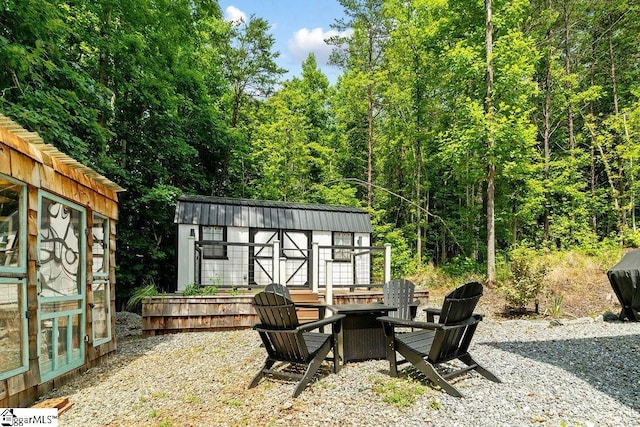 view of patio featuring an outdoor fire pit and a shed