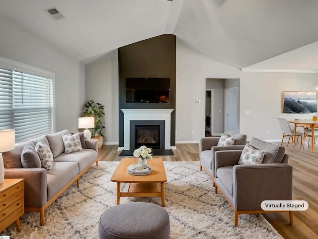 living room featuring lofted ceiling and light hardwood / wood-style floors