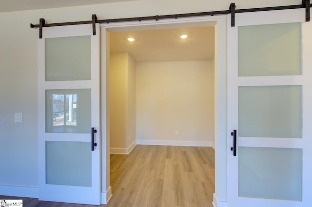 interior space featuring a barn door and light hardwood / wood-style flooring