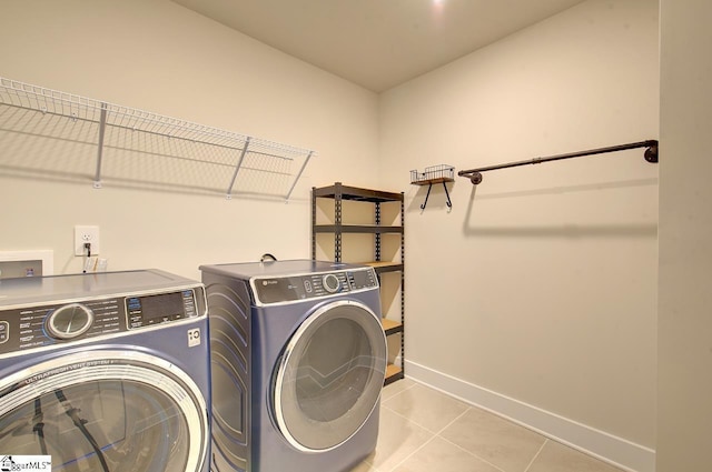 laundry room with washer and dryer and light tile patterned floors