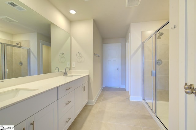 bathroom featuring a shower with door, vanity, and tile patterned floors