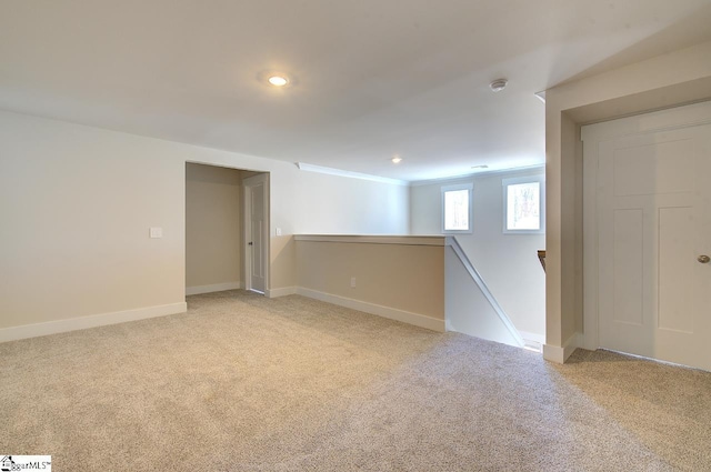 basement with crown molding and light colored carpet