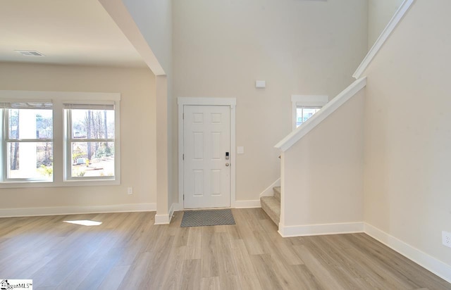 foyer entrance featuring a high ceiling and light hardwood / wood-style floors