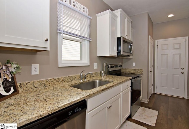 kitchen featuring sink, light stone counters, dark hardwood / wood-style floors, stainless steel appliances, and white cabinets