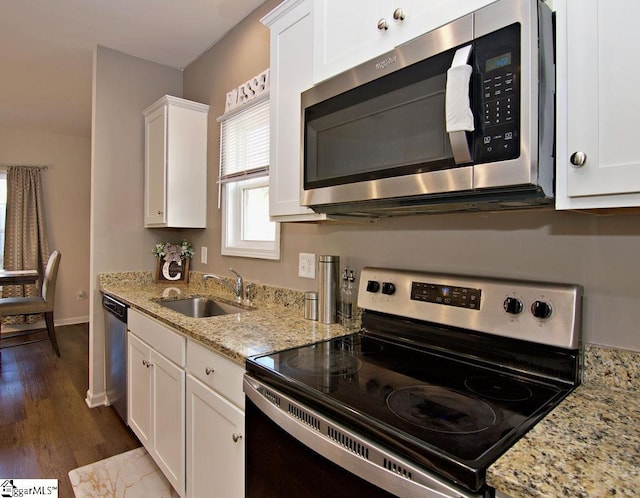 kitchen with light stone countertops, appliances with stainless steel finishes, sink, and white cabinets