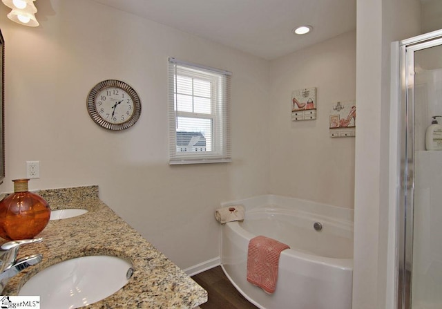 bathroom featuring vanity, a bath, and hardwood / wood-style floors