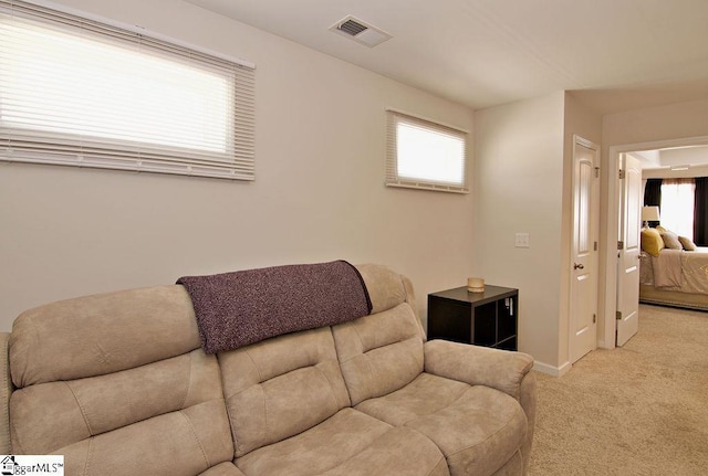 living room featuring plenty of natural light and light colored carpet