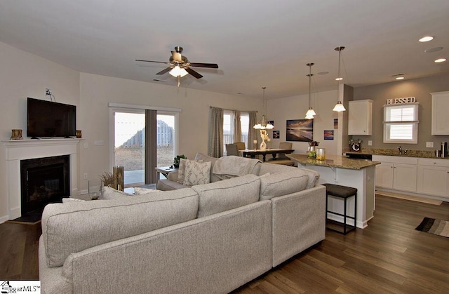 living room featuring ceiling fan, dark hardwood / wood-style flooring, and sink