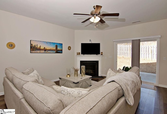 living room with ceiling fan and dark hardwood / wood-style flooring