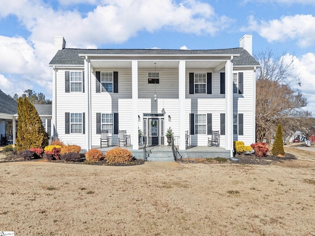 view of front of house featuring covered porch and a front lawn