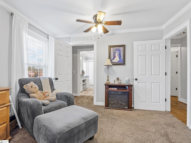 sitting room featuring crown molding, ceiling fan, and carpet flooring