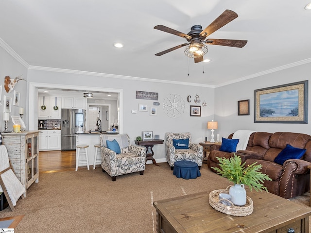 living room featuring ceiling fan, ornamental molding, and carpet