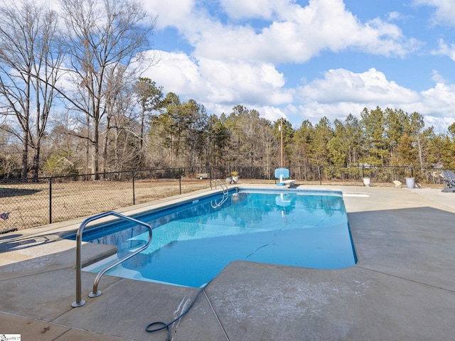 view of swimming pool featuring a patio area and a diving board