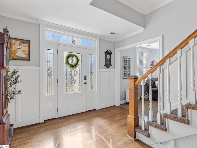 entryway with crown molding and light hardwood / wood-style flooring