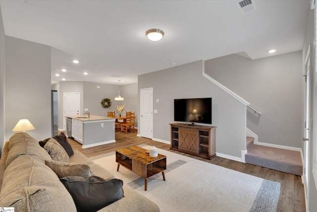 living room with sink and light wood-type flooring