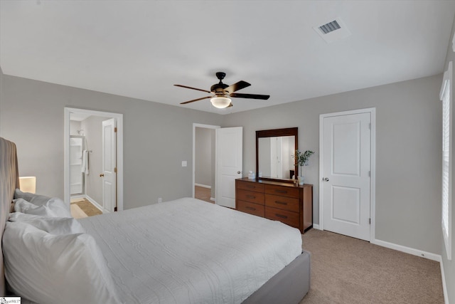 bedroom featuring connected bathroom, light colored carpet, and ceiling fan