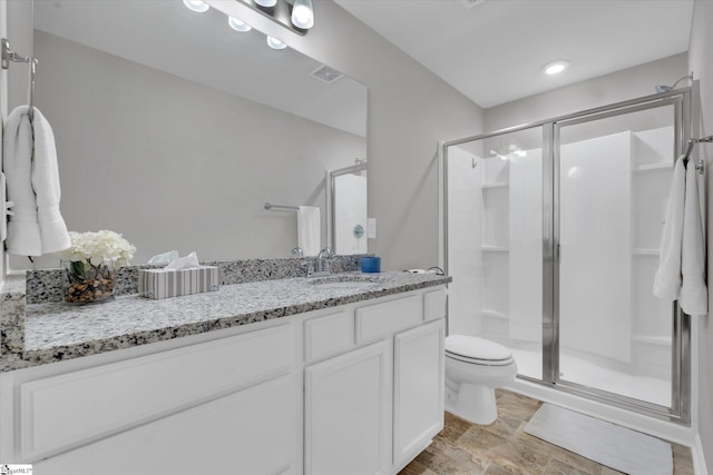 bathroom featuring vanity, toilet, and an enclosed shower