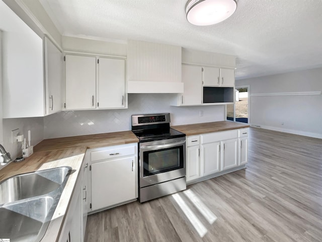 kitchen with white cabinetry, wood counters, and electric range