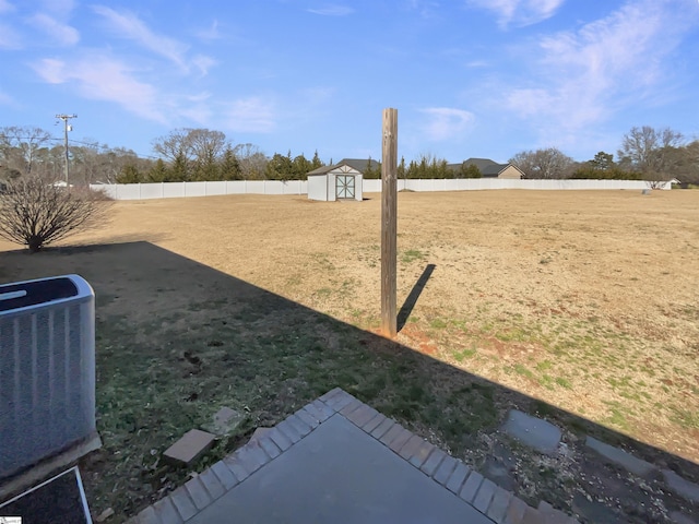 view of yard featuring central AC unit and a storage unit