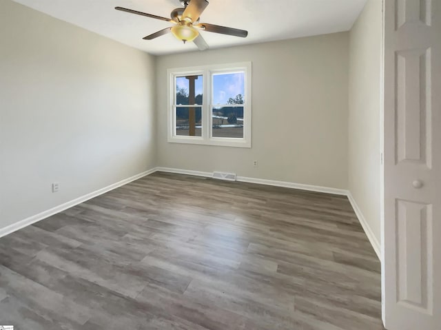 empty room with dark wood-type flooring and ceiling fan