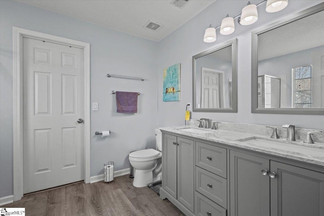 bathroom featuring vanity, hardwood / wood-style floors, toilet, and walk in shower