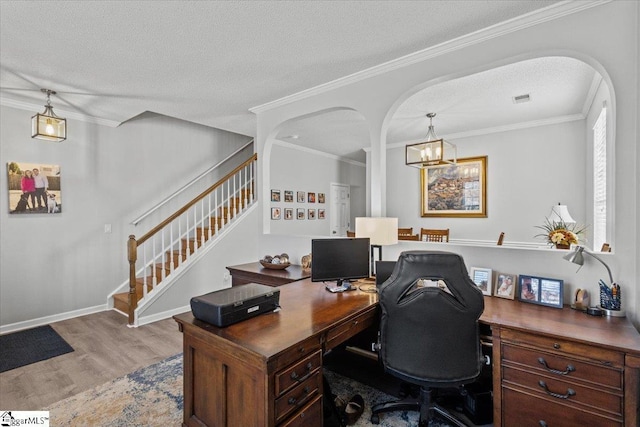 office space featuring crown molding, a chandelier, a textured ceiling, and light wood-type flooring