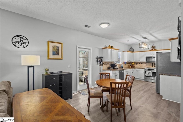 dining room featuring sink, hardwood / wood-style floors, and a textured ceiling