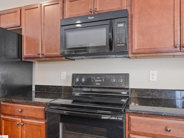 kitchen with dark stone counters and black appliances