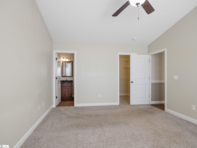 unfurnished bedroom with lofted ceiling, ensuite bath, a spacious closet, carpet floors, and a closet