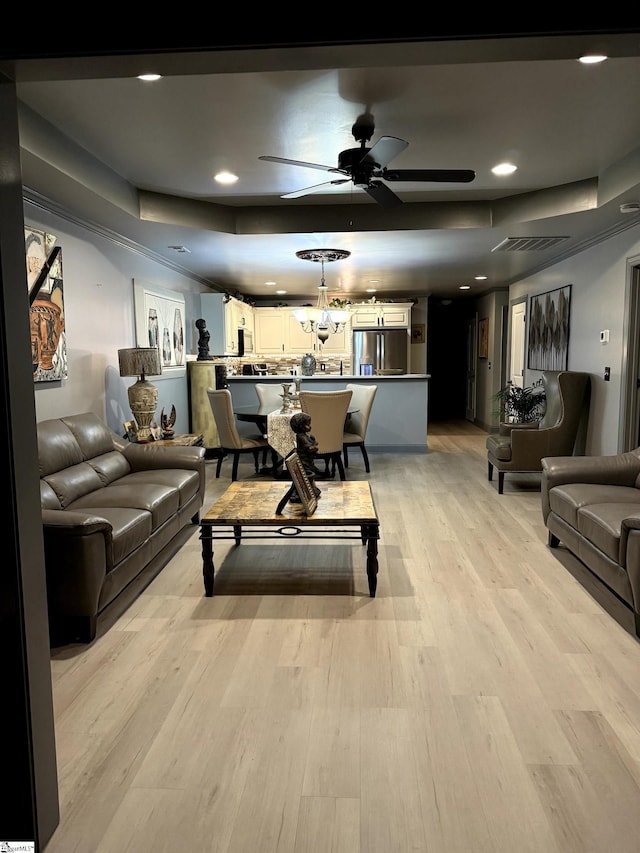 living room with ceiling fan and light hardwood / wood-style flooring