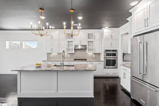 kitchen with white cabinetry, stainless steel appliances, decorative light fixtures, and sink