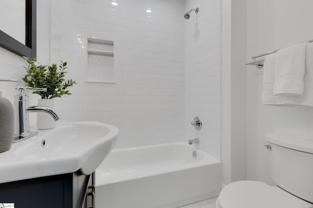 full bathroom featuring tiled shower / bath, toilet, and sink