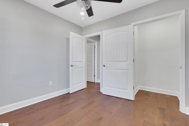 unfurnished bedroom featuring dark wood-type flooring and ceiling fan