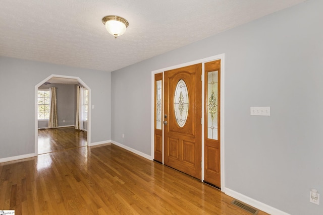 entrance foyer with hardwood / wood-style floors and a textured ceiling