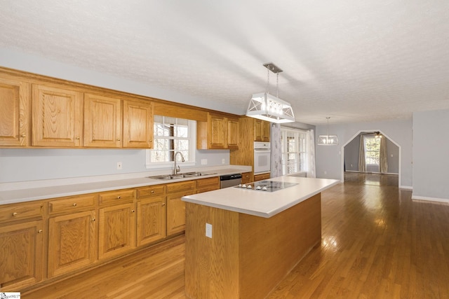 kitchen with sink, white oven, black electric stovetop, a kitchen island, and stainless steel dishwasher