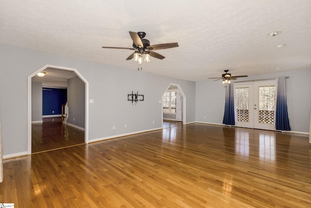 unfurnished living room with hardwood / wood-style flooring, ceiling fan, a textured ceiling, and french doors