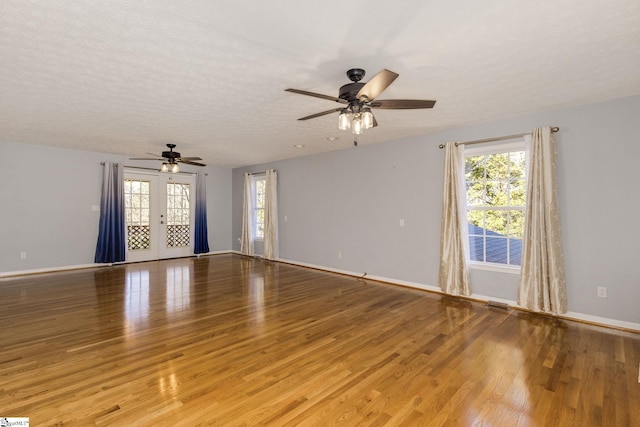 unfurnished room with ceiling fan, a textured ceiling, and light wood-type flooring