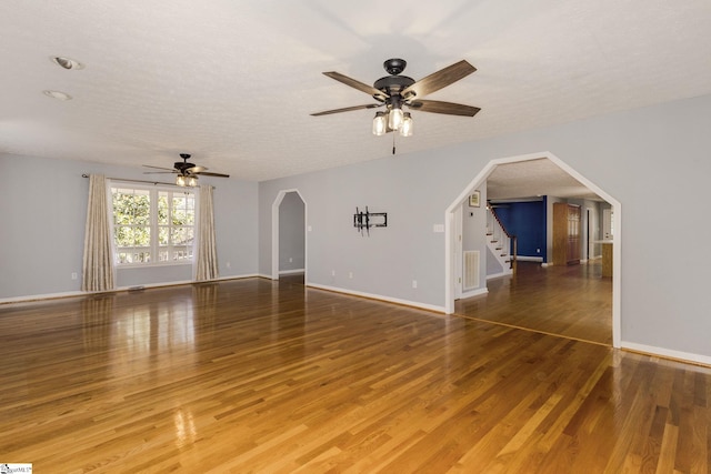 unfurnished living room with hardwood / wood-style flooring, a textured ceiling, and ceiling fan