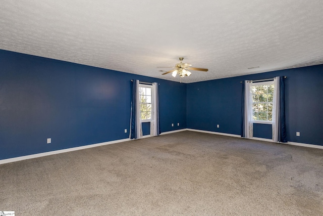 carpeted spare room with ceiling fan and a textured ceiling