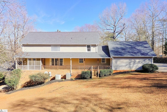 rear view of house featuring central AC and a lawn