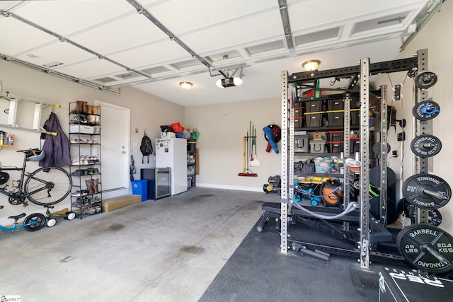 garage with a garage door opener and white fridge