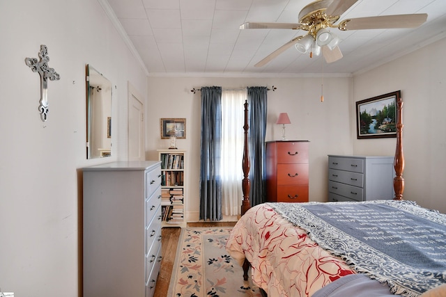 bedroom with hardwood / wood-style flooring, ornamental molding, and ceiling fan