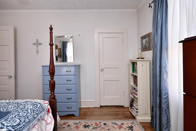 bedroom with dark hardwood / wood-style flooring and ornamental molding