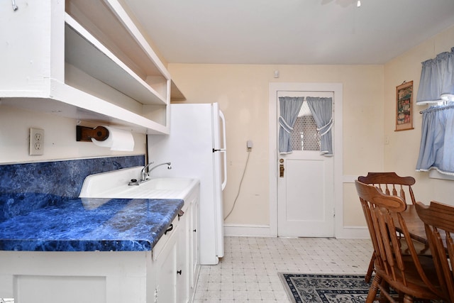 kitchen featuring white cabinetry and white fridge