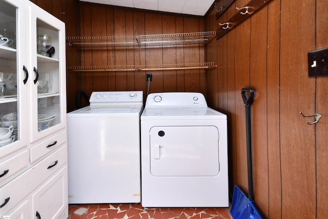 laundry room featuring washer and dryer and wood walls