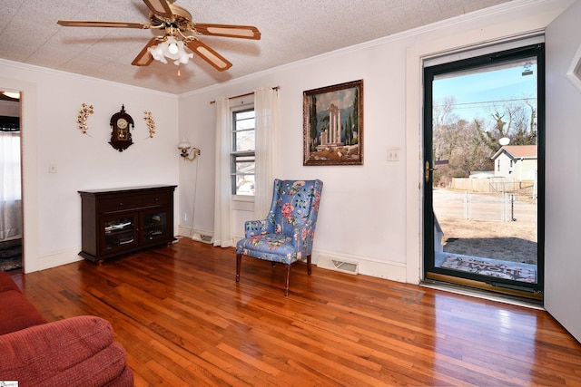 sitting room featuring ceiling fan, ornamental molding, dark hardwood / wood-style floors, and a textured ceiling