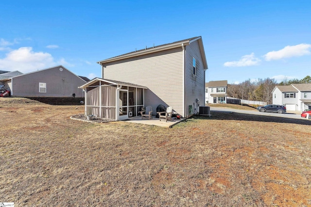 back of property with central AC, a sunroom, a patio, and a lawn