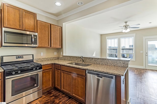 kitchen featuring sink, dark wood-type flooring, kitchen peninsula, and appliances with stainless steel finishes