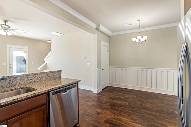 kitchen with sink, light stone counters, decorative light fixtures, dark hardwood / wood-style floors, and stainless steel appliances