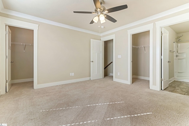 unfurnished bedroom with crown molding, ensuite bath, a walk in closet, light colored carpet, and a closet